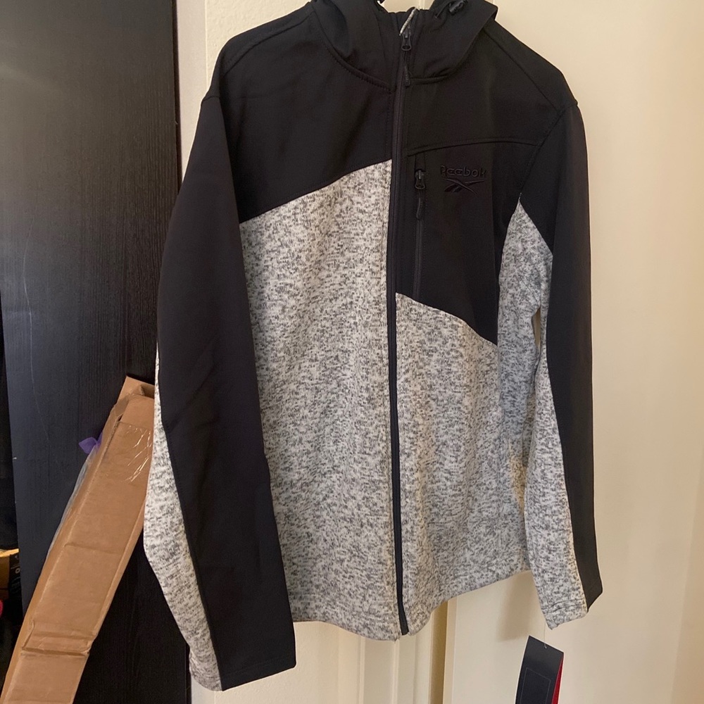 Black and grey full zip Reebok hoodie.